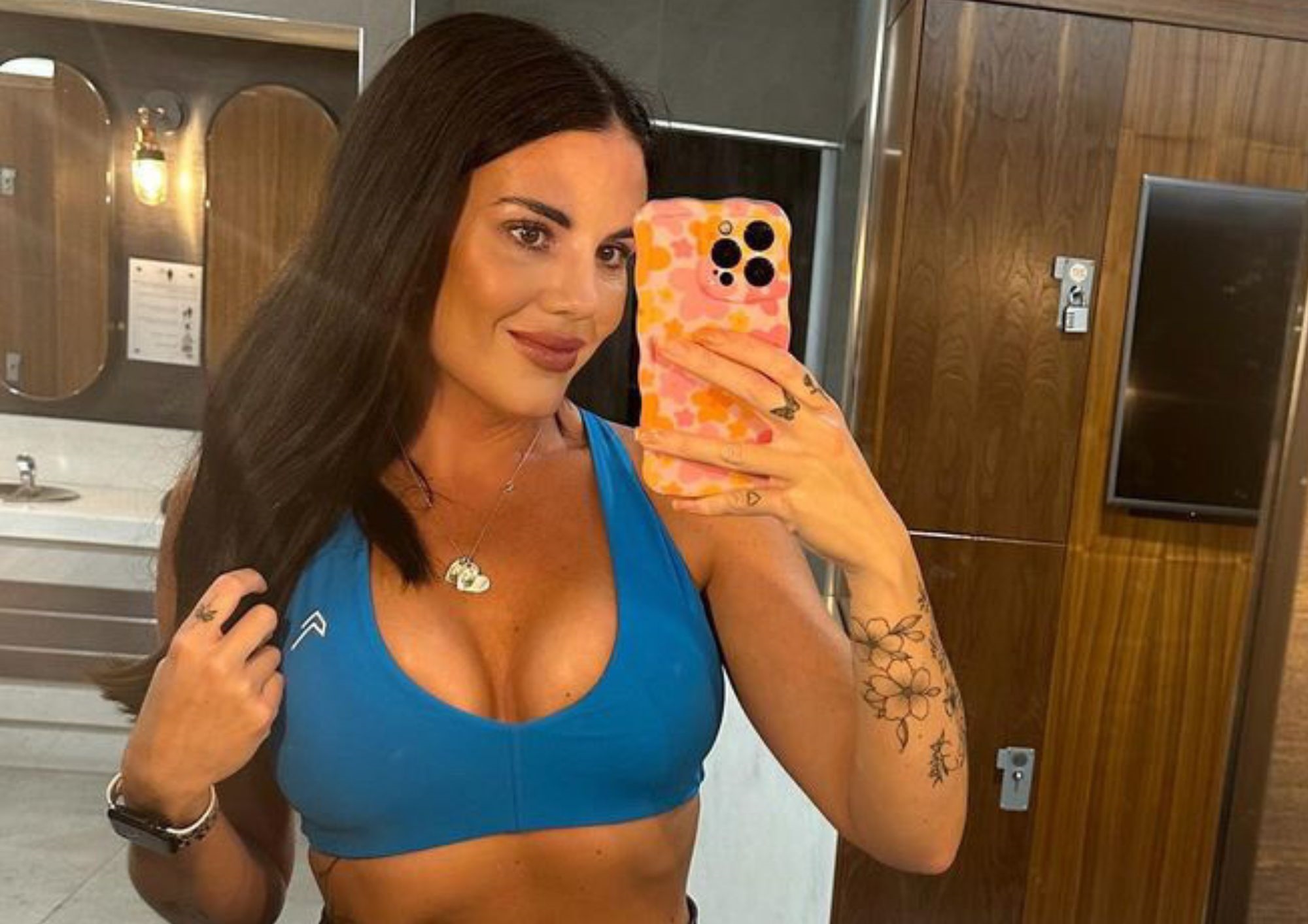 Woman taking a selfie in a mirror at the gym Woman taking a selfie in a mirror at the gym
